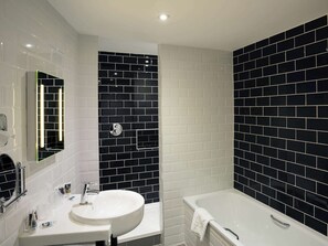 Features a sleek bathroom with a wall-mounted mirror, sink, and spacious bathtub.