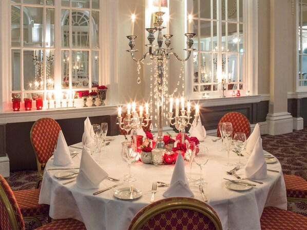 Formal dining area with a round table, ornate chairs, and elegant centerpiece.
