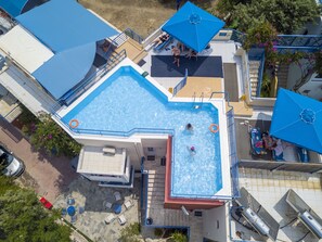 Una piscina al aire libre, sombrillas, tumbonas