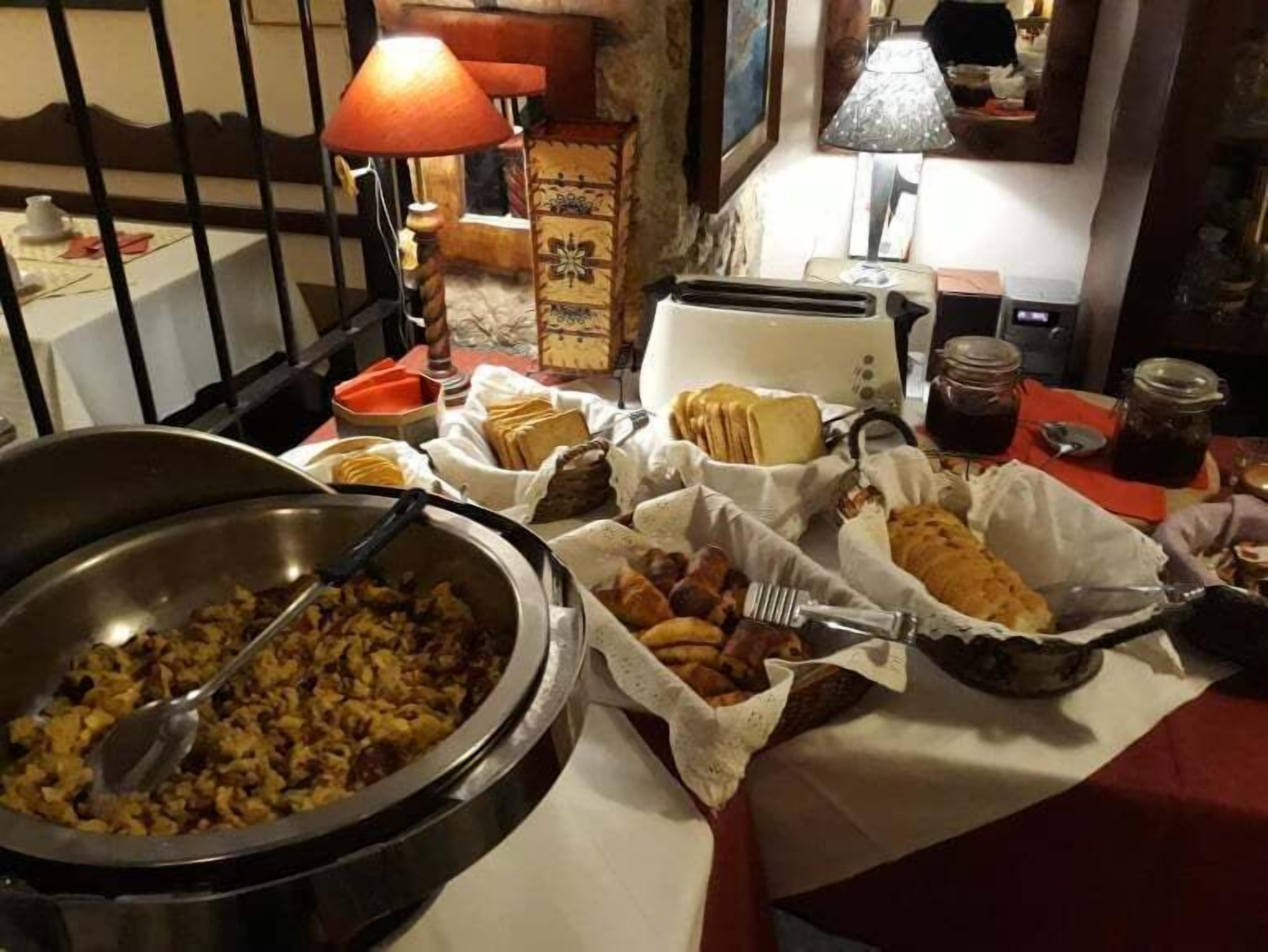 A buffet table with various food items, a toaster, and a lamp.