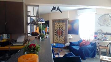 A living room with a sofa, a coffee table, and a kitchen area with a counter.