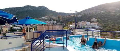 Una piscina al aire libre, sombrillas, tumbonas