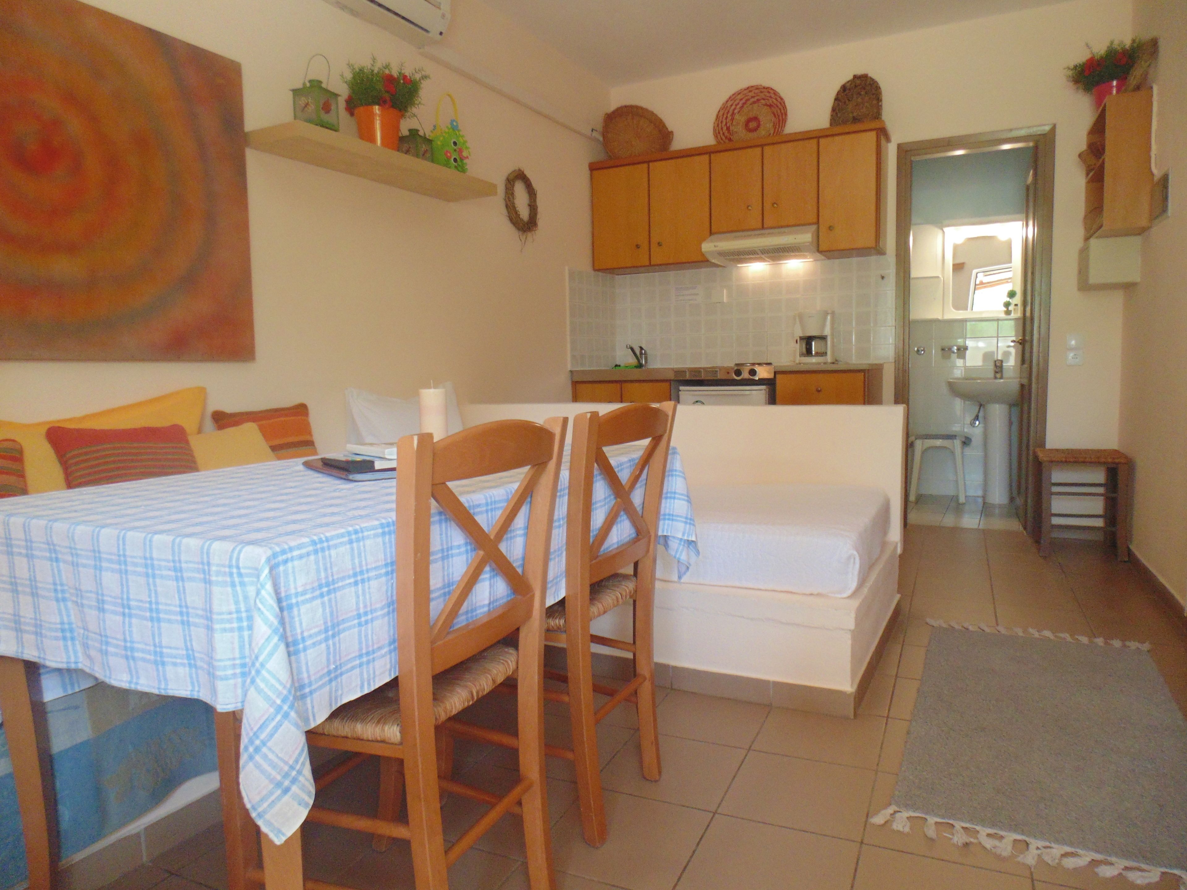 A compact living space with a dining area, kitchenette, and a bathroom.