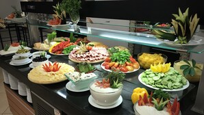 A buffet with various food items including salads, fruits, and meats. - Ambassador Hotel (Jerusalem)