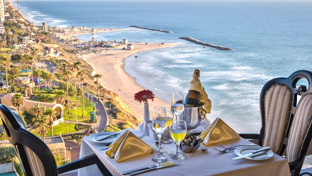 Mesa para dos con vista al océano y a la playa.