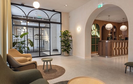 A modern lobby with seating areas, a reception desk, and a glass entrance.
