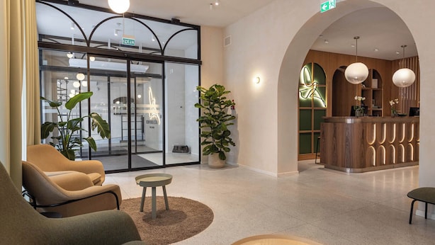 A modern lobby with seating areas, a reception desk, and a glass entrance.