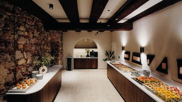 A buffet area with a stone wall, wooden beams, and a tiled floor.