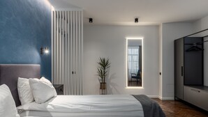 A modern bedroom with two beds, a large mirror, a wardrobe, and a potted plant. - Konventa Sēta Hotel - Keystone Collection (Riga)