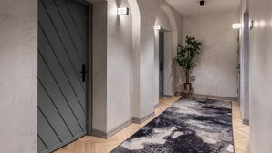 A hallway with a patterned carpet, a potted plant, and doors labeled 005, 006, and 007.