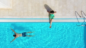 Una piscina con agua cristalina y un borde con mosaicos.