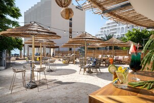 Una piscina techada, una piscina al aire libre, sombrillas