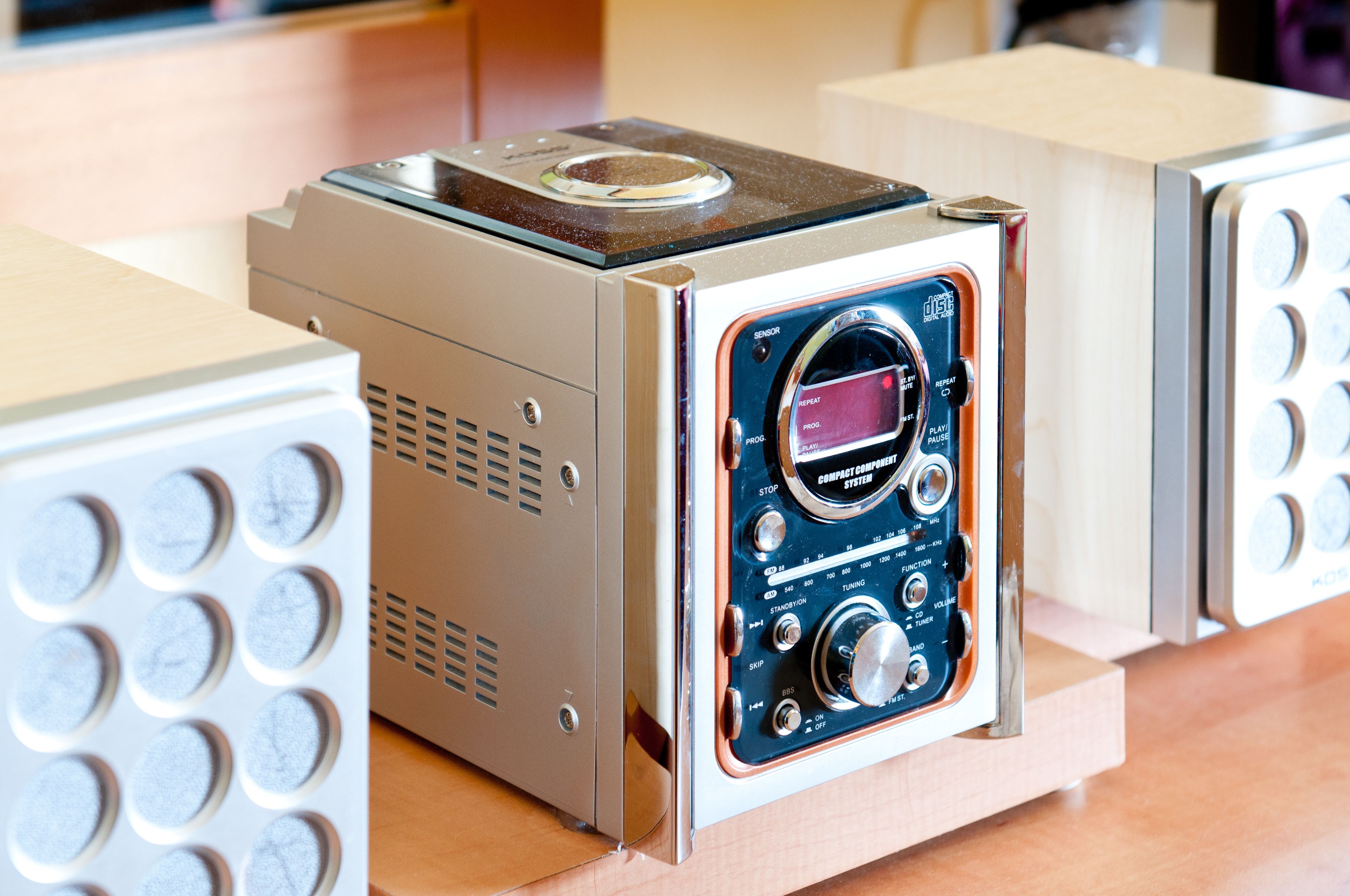 Een compact, modern apparaat met een digitaal display en meerdere bedieningsknoppen, waarschijnlijk audioapparatuur.