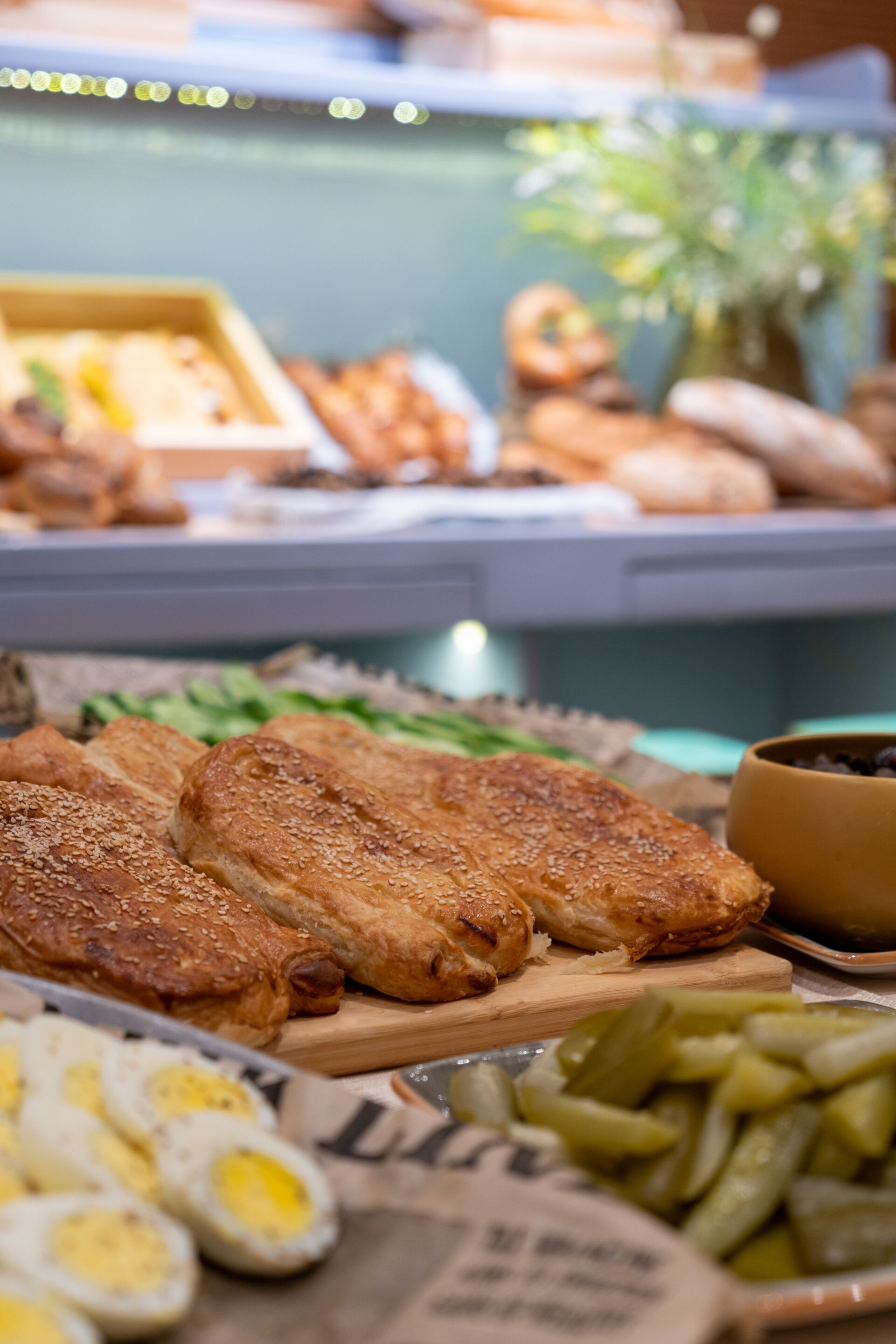 Un bufé con distintos alimentos, como pescado rebozado, huevos y pepinillos.