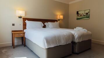 Una habitación de hotel con una cama grande, dos mesitas de noche y un cuadro en la pared.