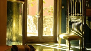 A room with a glass table, a chair, a bowl on a pedestal, and a door leading outside. - Boutique Hotel Vozdvyzhensky (Kyiv)