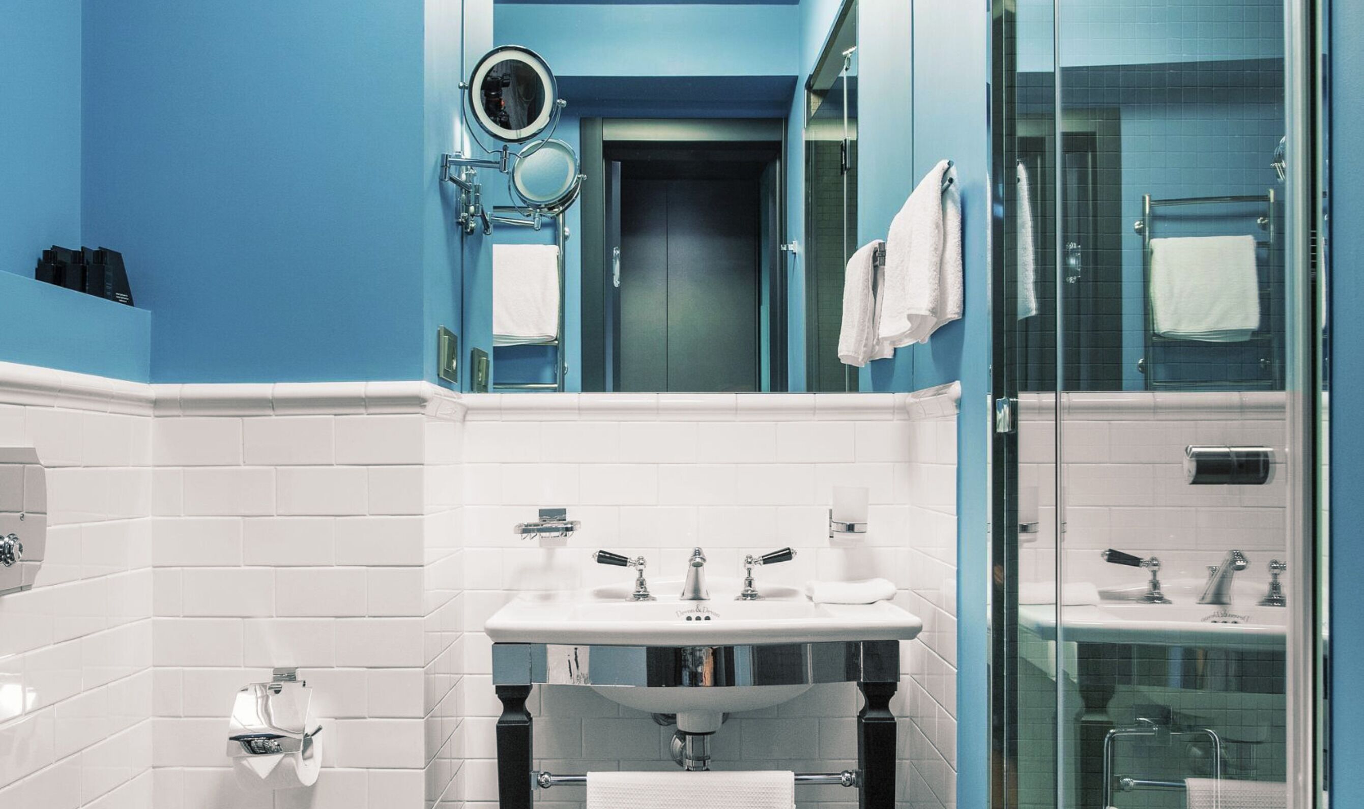 Ein modernes Badezimmer mit zwei Waschbecken, einem Spiegel und einer Duschkabine aus Glas.