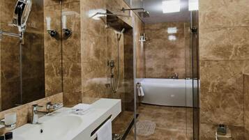 Un baño moderno con lavamanos blanco, cabina de ducha con mampara de vidrio y bañera.
