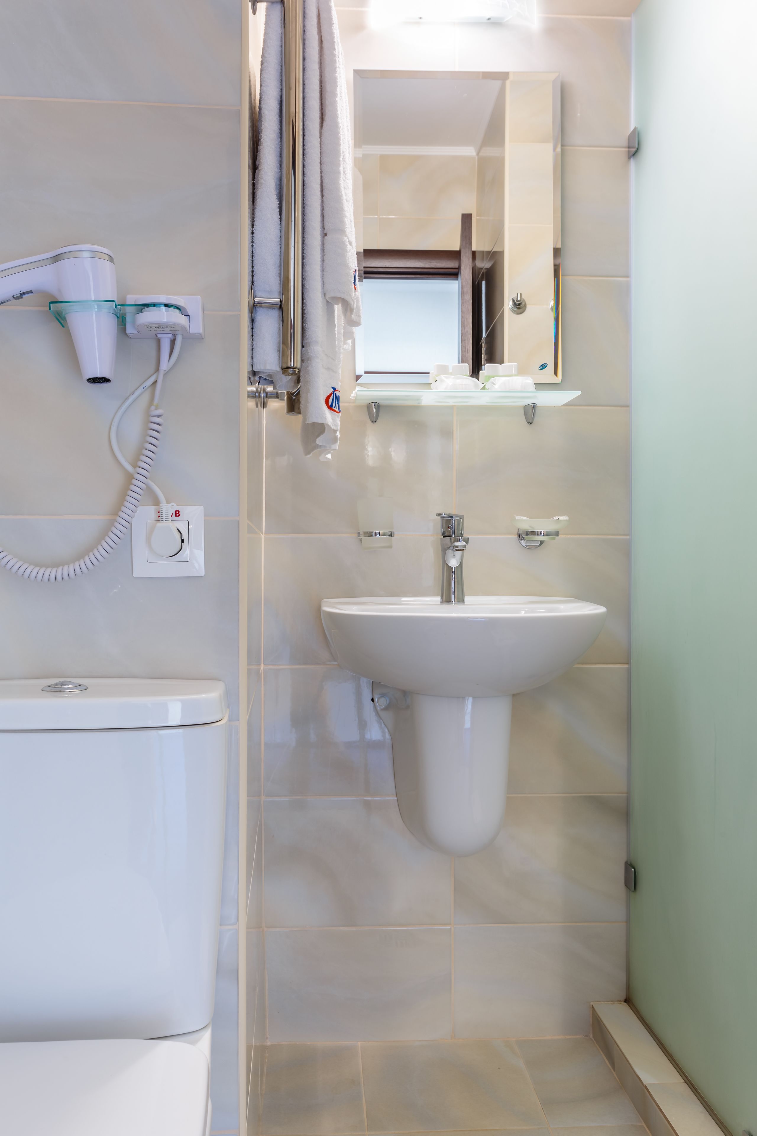 Une salle de bain moderne équipée de toilettes, d’un lavabo et d’un porte-serviettes.