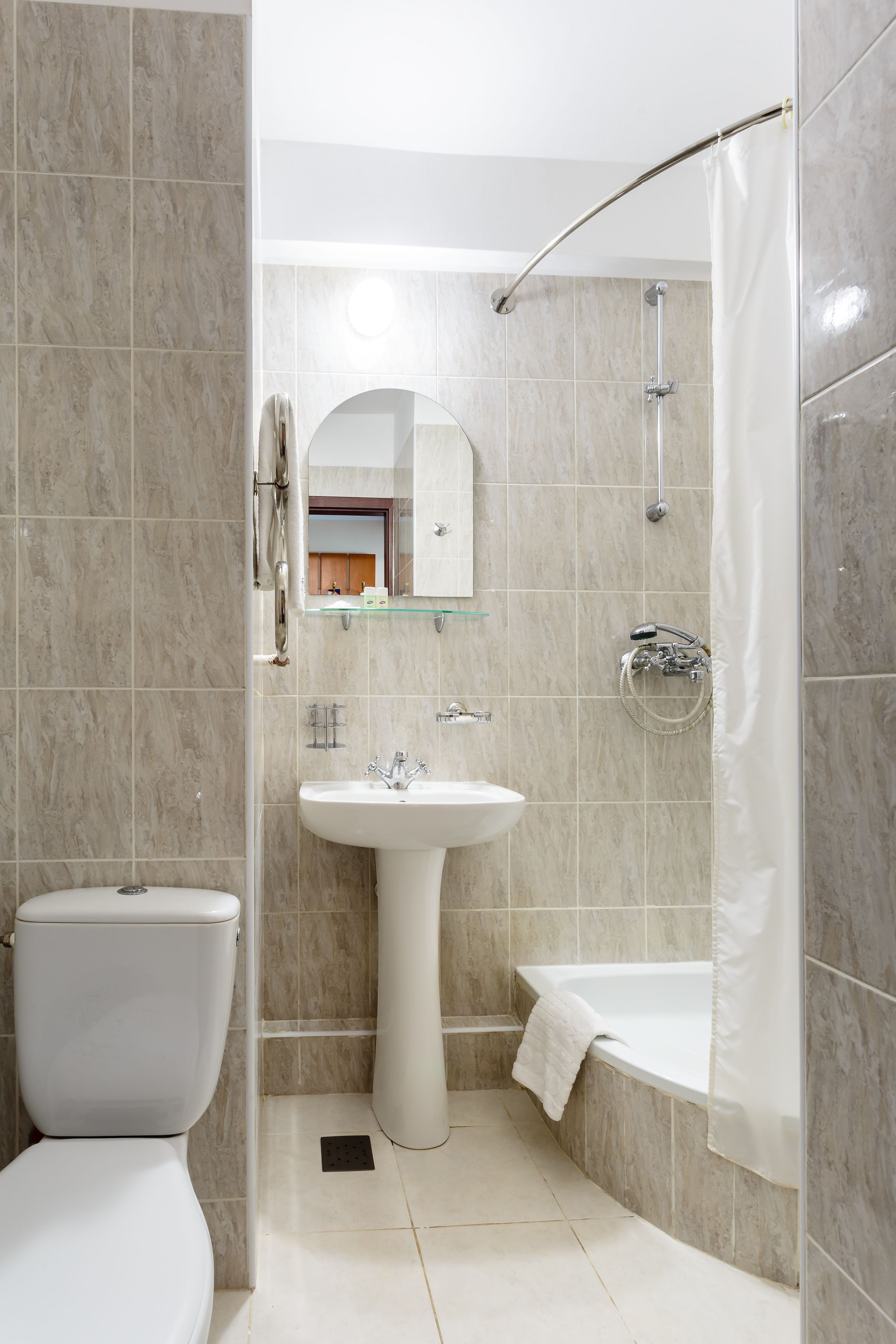 A bathroom with a toilet, sink, and bathtub.