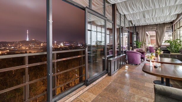 A modern hotel room with large windows offering a city view, including a tower. - Premier Hotel Dnister (Lviv)