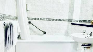 A bathroom with a bathtub, a sink, and a shower.