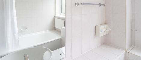 Un baño moderno con bañera, lavabo y cabina de ducha.