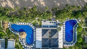 An aerial view of a resort with two swimming pools, a beach, and palm trees. - Sunprime Kamala Beach (Kamala)