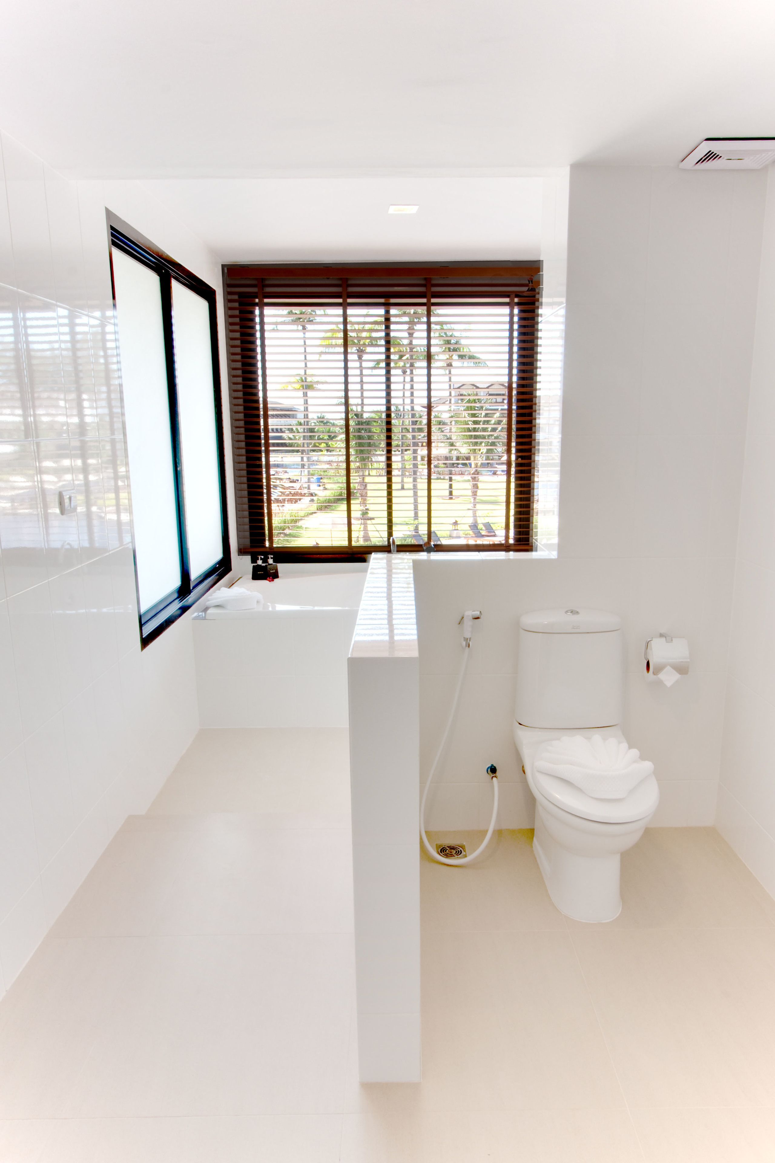 A modern bathroom with a toilet, sink, and window.