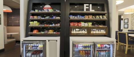 A beverage fridge with snacks and a sign indicating 'Treats' above it.