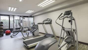 Ein Fitnessstudio mit Laufbändern, Crosstrainern und Kurzhanteln.