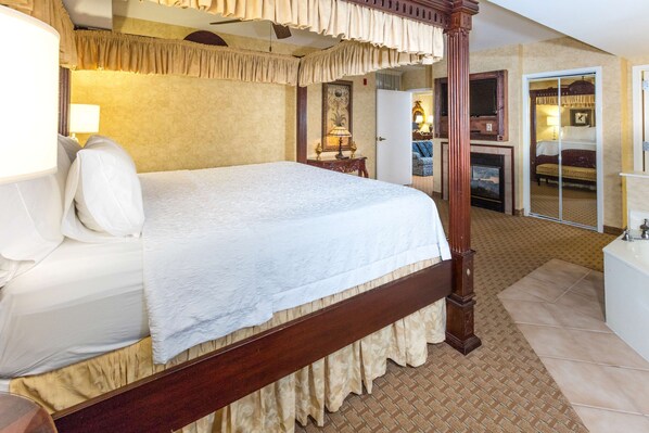 A four-poster bed with a wooden frame and a white bedspread. - Hampton Inn and Suites Amelia Island Historic Harbor Front (Fernandina Beach)