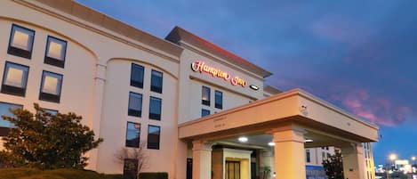 Un hotel Hampton Inn con entrada despejada, un pasillo cubierto y una zona de estacionamiento.