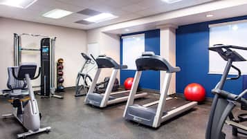 A gym with treadmills, elliptical machines, and a weight machine.