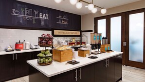 Una barra de desayuno moderna con un cartel de pizarra, diversos alimentos y vista al exterior.