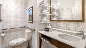 A bathroom with a toilet, a sink, a mirror, and a towel rack.