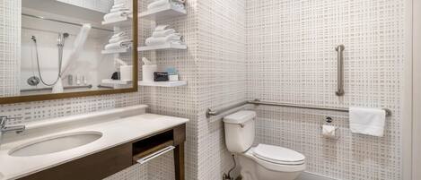 A modern bathroom with a sink, mirror, toilet, and shower.