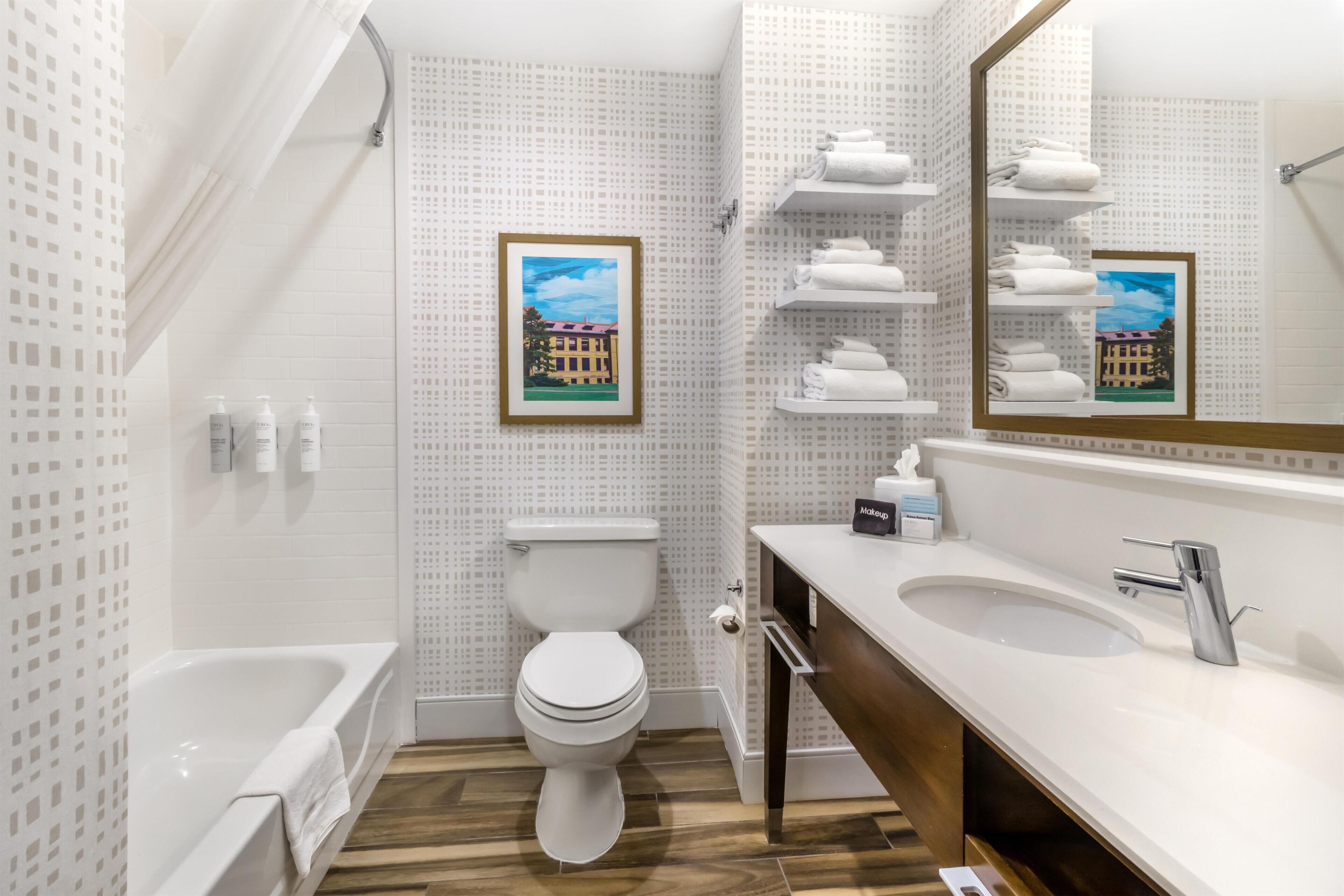 Un baño moderno con bañera, inodoro y tocador.
