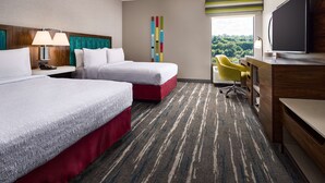 A hotel room with two beds, a desk with a TV, a chair, and a view of the outdoors. - Hampton Inn Massillon (Massillon)
