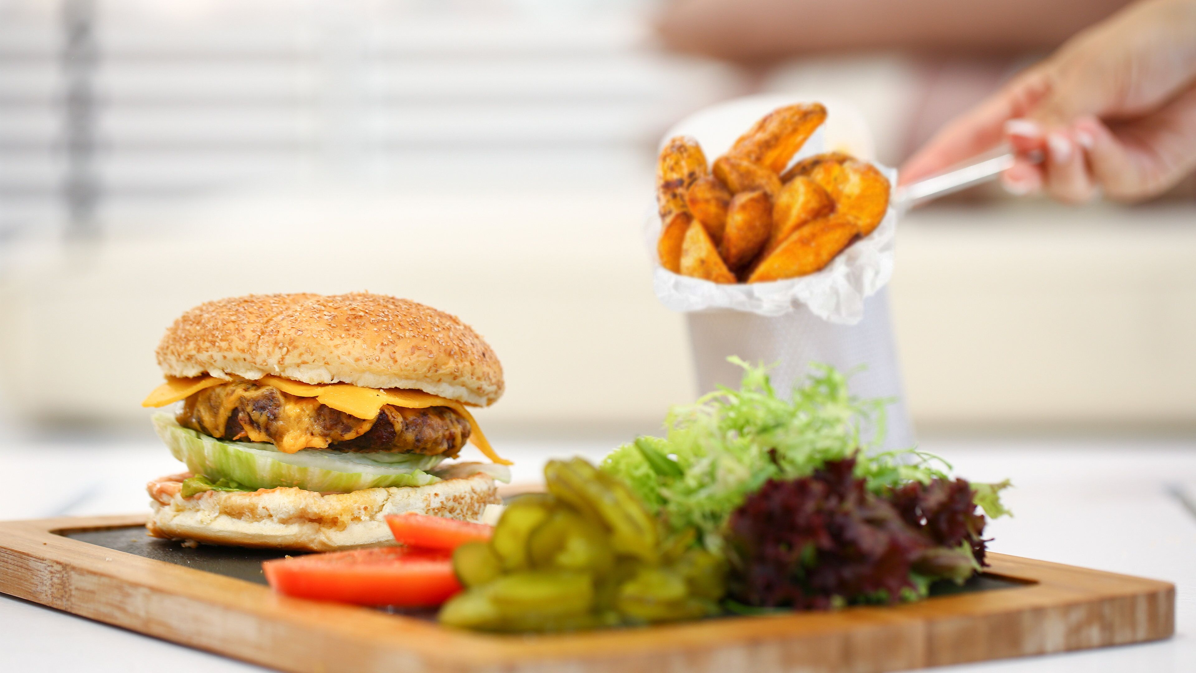 Un plato con una hamburguesa, papas fritas y una ensalada.