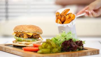 Un plato con una hamburguesa, papas fritas y una ensalada.