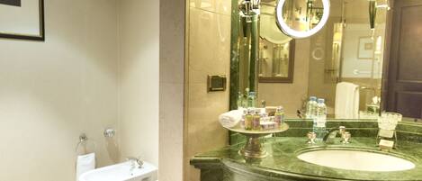 A bathroom with two sinks, a large mirror, and a vanity with toiletries.