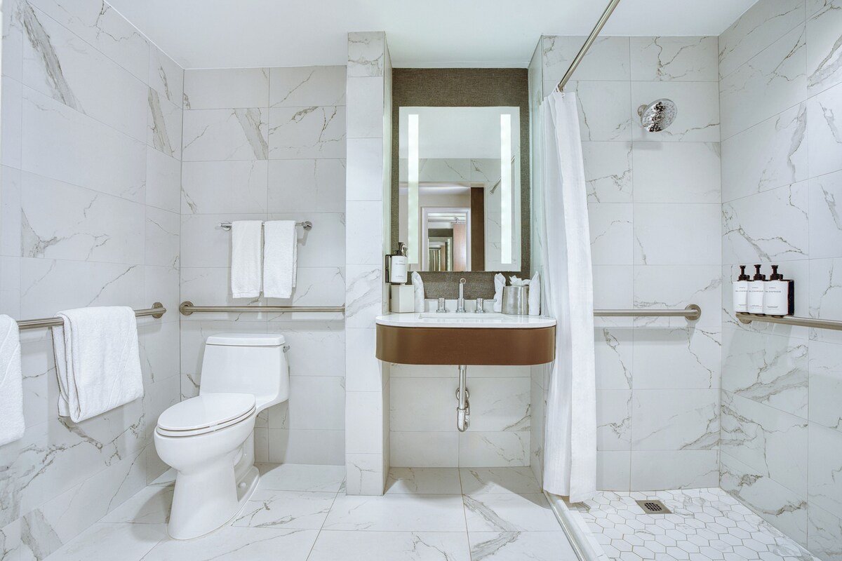 A modern bathroom with a toilet, sink, and shower area.
