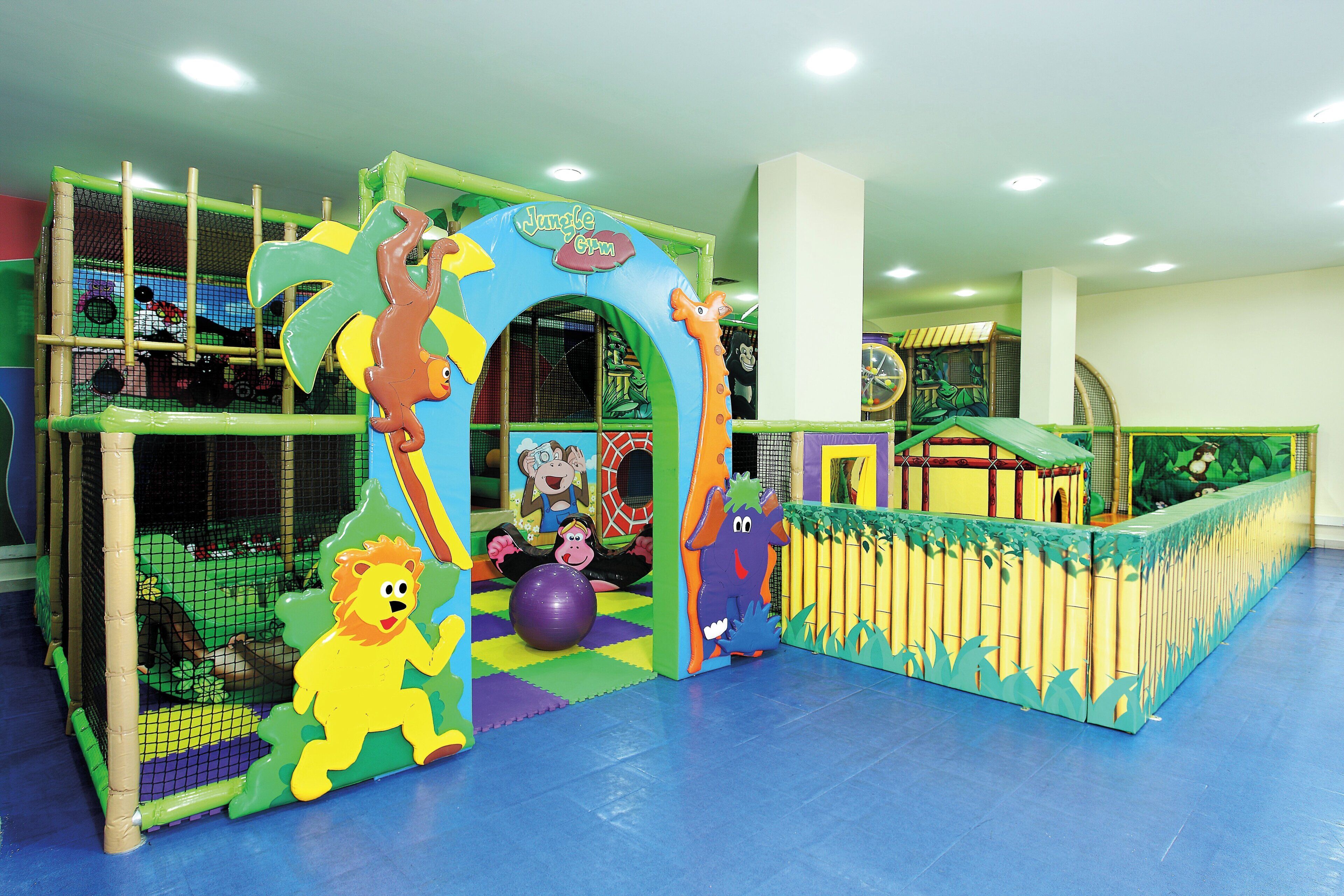 Un espace de jeux pour enfants comprenant diverses structures ludiques et des filets de sécurité.
