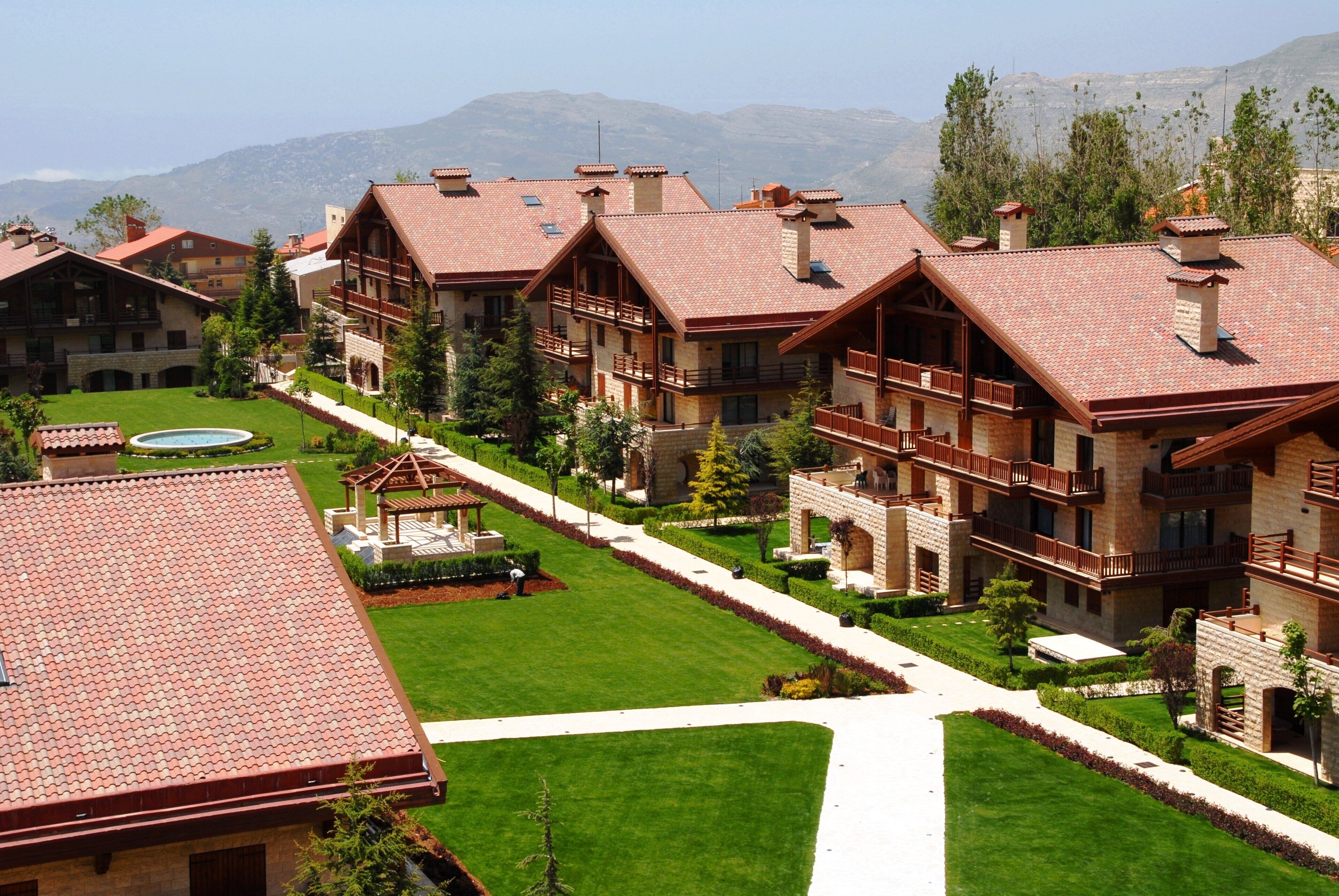 Ein Hotel mit mehreren Gebäuden, jedes mit rotem Ziegeldach und Holzbalkonen.