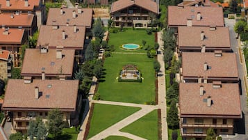 An aerial view of a residential area with multiple two-story houses, each with a tiled roof and a central courtyard.