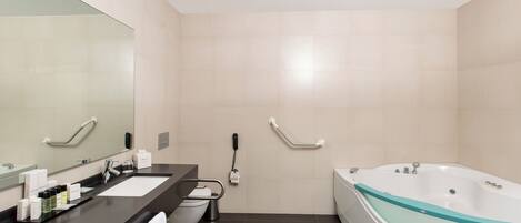 A modern bathroom with two sinks, a large mirror, a toilet, and a bathtub.