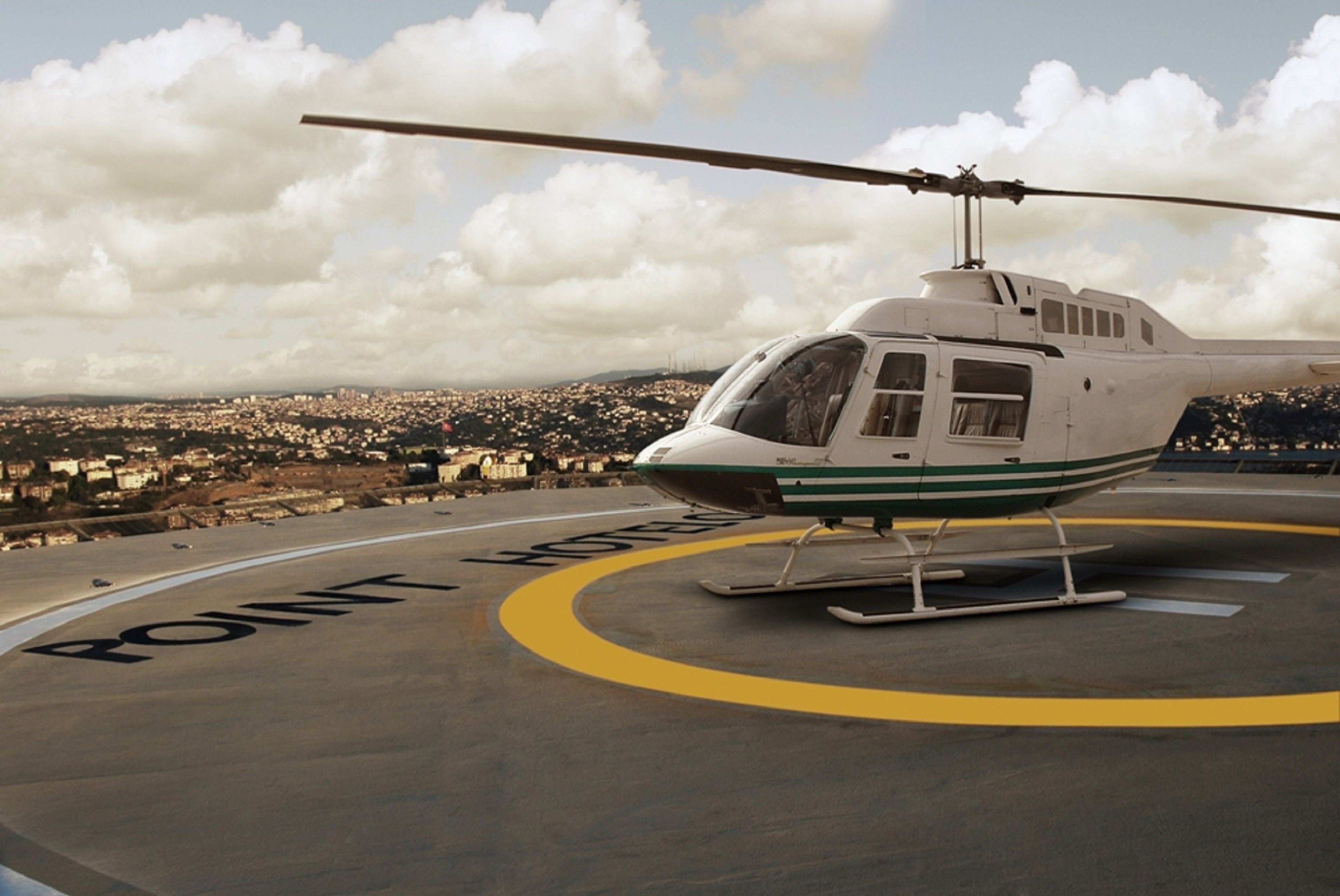 Un helicóptero estacionado en una plataforma de aterrizaje con las palabras “POINT” y “HOSPITAL” visibles en el suelo.