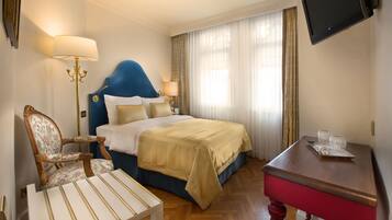 Ein Hotelzimmer mit Bett, Schreibtisch, Stuhl und Fernseher.