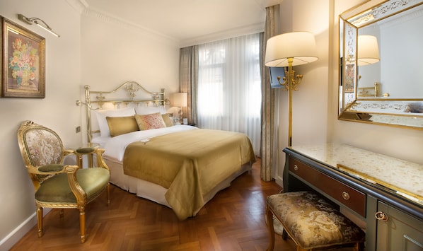 A classic hotel room with a large bed, a gold-framed chair, a wooden floor, and a large mirror with a gold frame. - Valide Sultan Konagi (Istanbul)